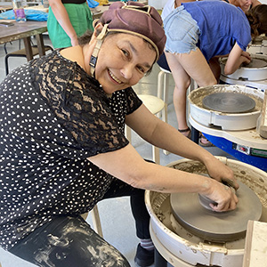 A photo of a woman wheel-throwing